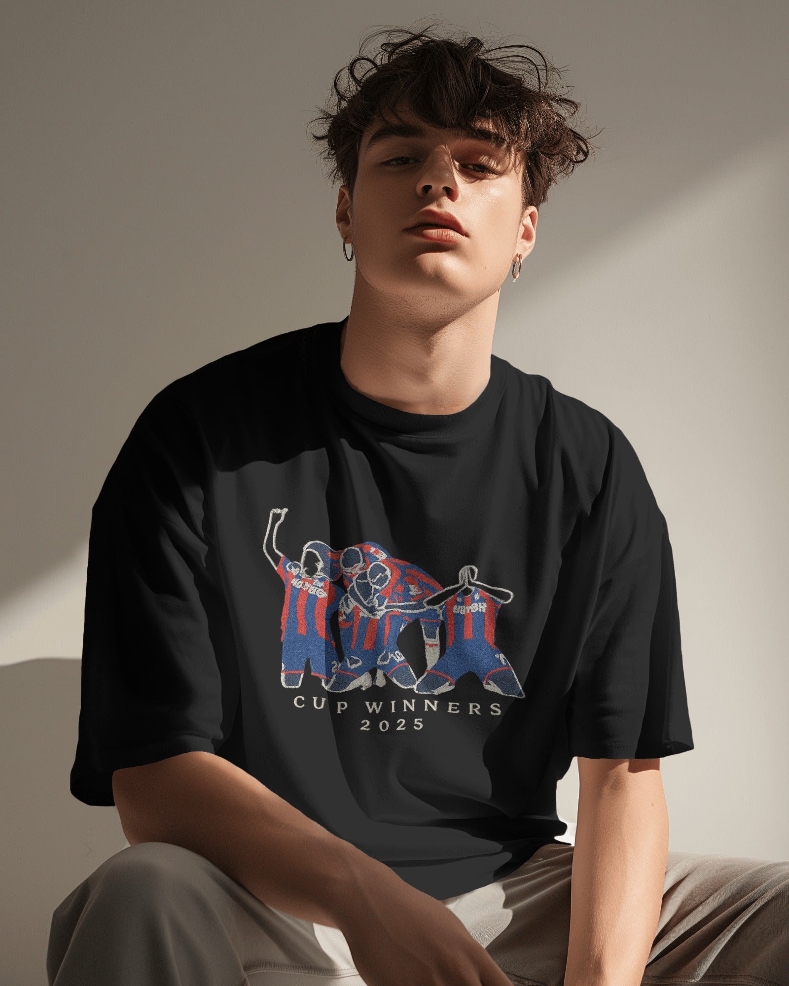 Person wearing a black t-shirt with a graphic design on a neutral background