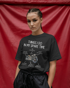 Person wearing a black t-shirt with text and motorcycle graphic against a red background